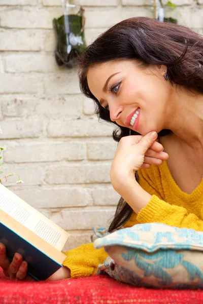 Mujer feliz leyendo libro y acostada afuera —  Fotos de Stock