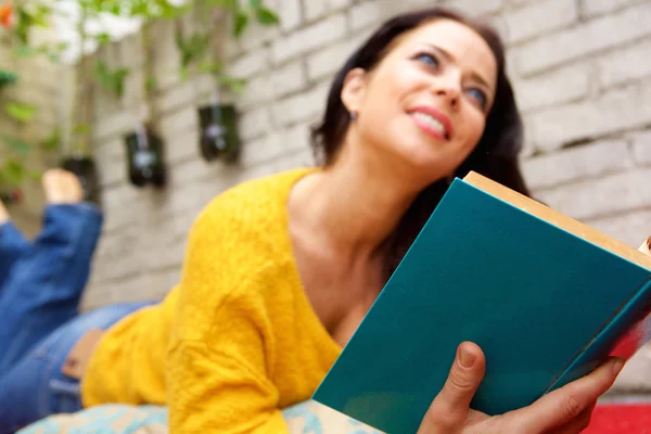 横になっている女性と外読書 — ストック写真