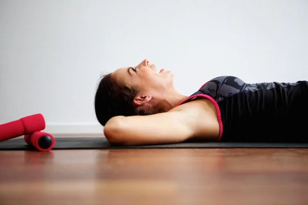 Lato della donna sdraiata sul tappetino yoga ridere — Foto Stock