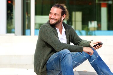 Müzik merdiven üzerinde oturan mutlu adam