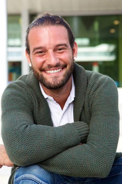 Man sitting with arms crossed smiling — Stock Photo, Image