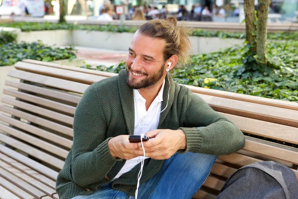 Человек, держащий мобильный телефон, слушающий музыку — стоковое фото