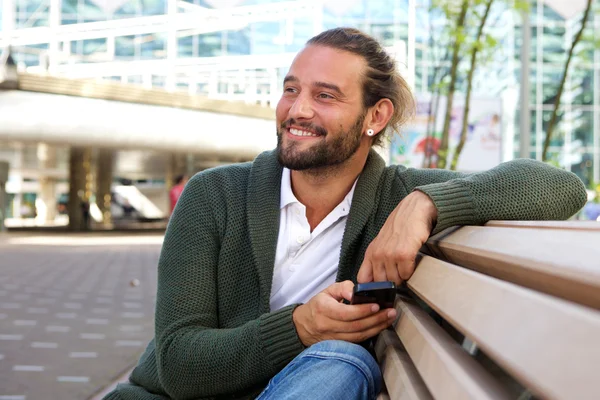 Smiling man sitting on bench — Stock Photo, Image