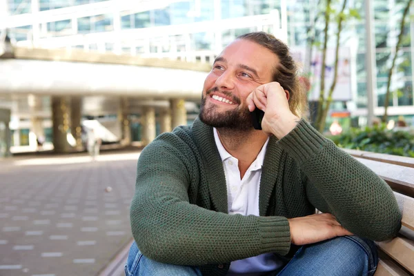 Guy with beard sitting on bench in the city — Stock Photo, Image