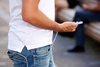 Cep telefonu ve harici pil ile yürüyen adam