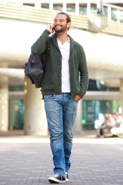 Yürüyüş ve cep telefonu üzerinde konuşurken adam 