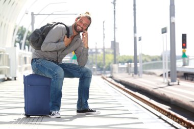 Tren platformu bekleyen telefonda konuşan adam