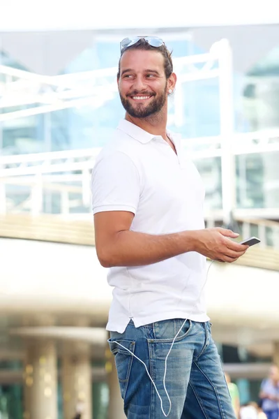 Красивый мужчина держит мобильник снаружи — стоковое фото