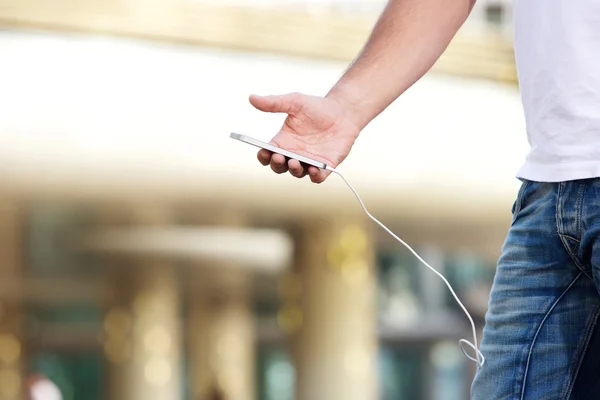 Hombre sosteniendo el teléfono móvil con cable de carga conectado —  Fotos de Stock