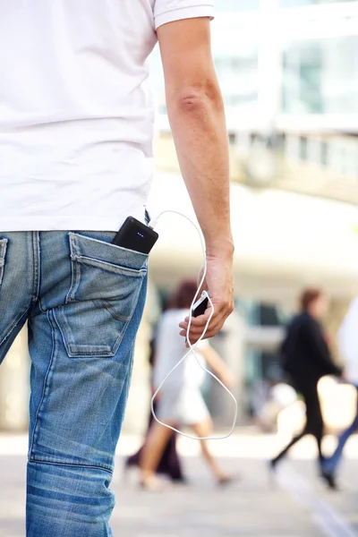Trzymając telefon komórkowy z ładowarką w kieszeni — Zdjęcie stockowe