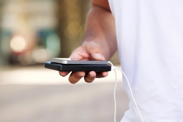 Hombre sosteniendo batería externa y teléfono inteligente —  Fotos de Stock