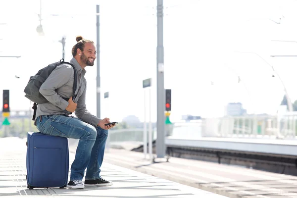 Chłodny człowiek czeka na dworzec kolejowy z torby — Zdjęcie stockowe