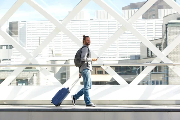 Hombre caminando con maleta y teléfono celular —  Fotos de Stock