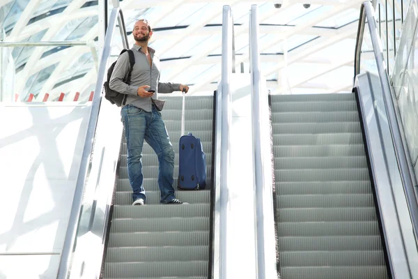 Seyahat adam çanta ile yürüyen merdiven üzerinde ayakta — Stok fotoğraf