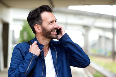 Cep telefonu üzerinde konuşurken neşeli olgun adam