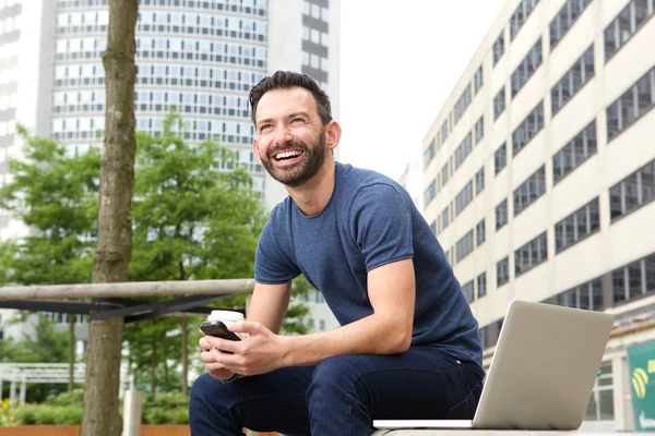 Hombre alegre sentado en el banco al aire libre — Foto de Stock