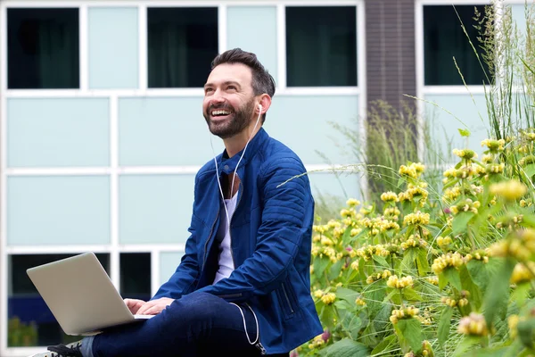 Gelukkig man luisteren naar muziek van de laptop — Stockfoto