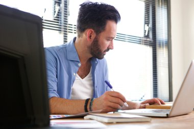 Olgun iş adamı masasında çalışıyor.