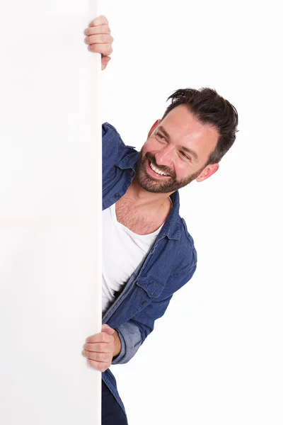 Happy mature man peeking over blank poster sign — Stock Photo, Image