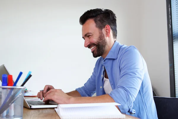 Glimlachende man aan het werk op zijn kantoor — Stockfoto