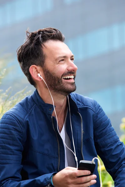 Bell'uomo che ascolta musica usando lo smart phone — Foto Stock