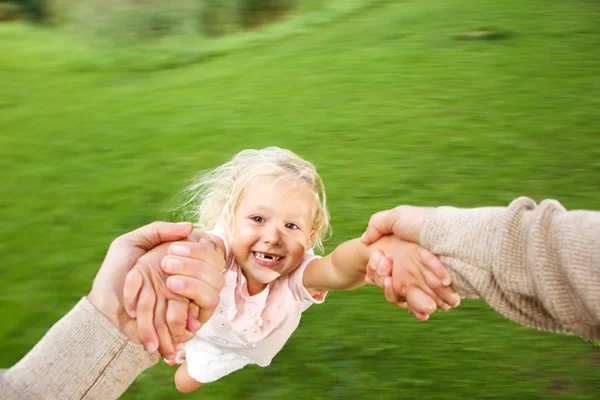 Girl being spun in circles at park — Stock Photo, Image