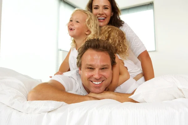 Família jovem desfrutando na cama — Fotografia de Stock