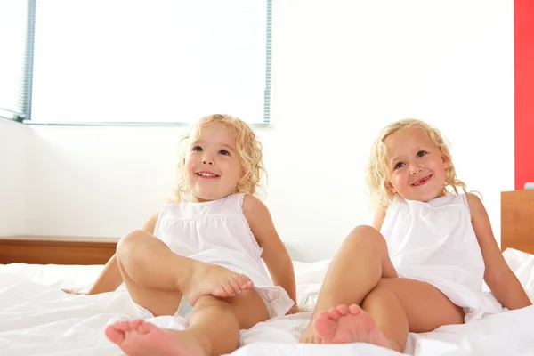 Twee kleine meisjes, die zich voordeed op bed — Stockfoto