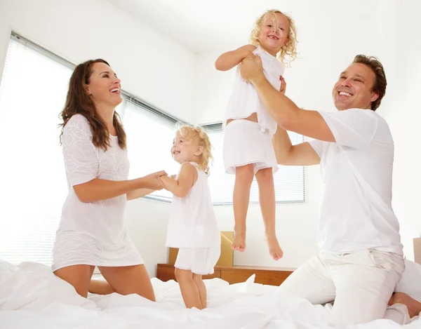 Cheerful family playing in bedroom — Stock fotografie