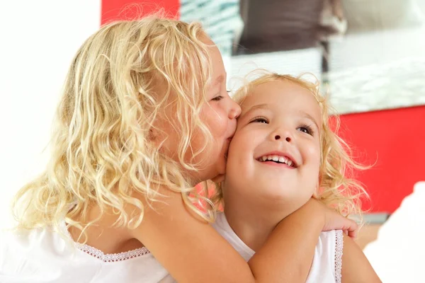 Klein meisje haar zus kussen — Stockfoto
