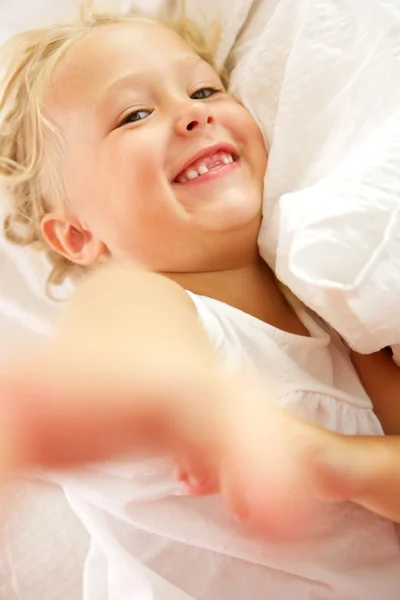 Schönes kleines Mädchen auf dem Bett liegend — Stockfoto