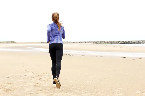 Mulher correndo na praia por mar — Fotografia de Stock