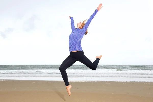 Woman in air with arms outstretched — Stock Photo, Image