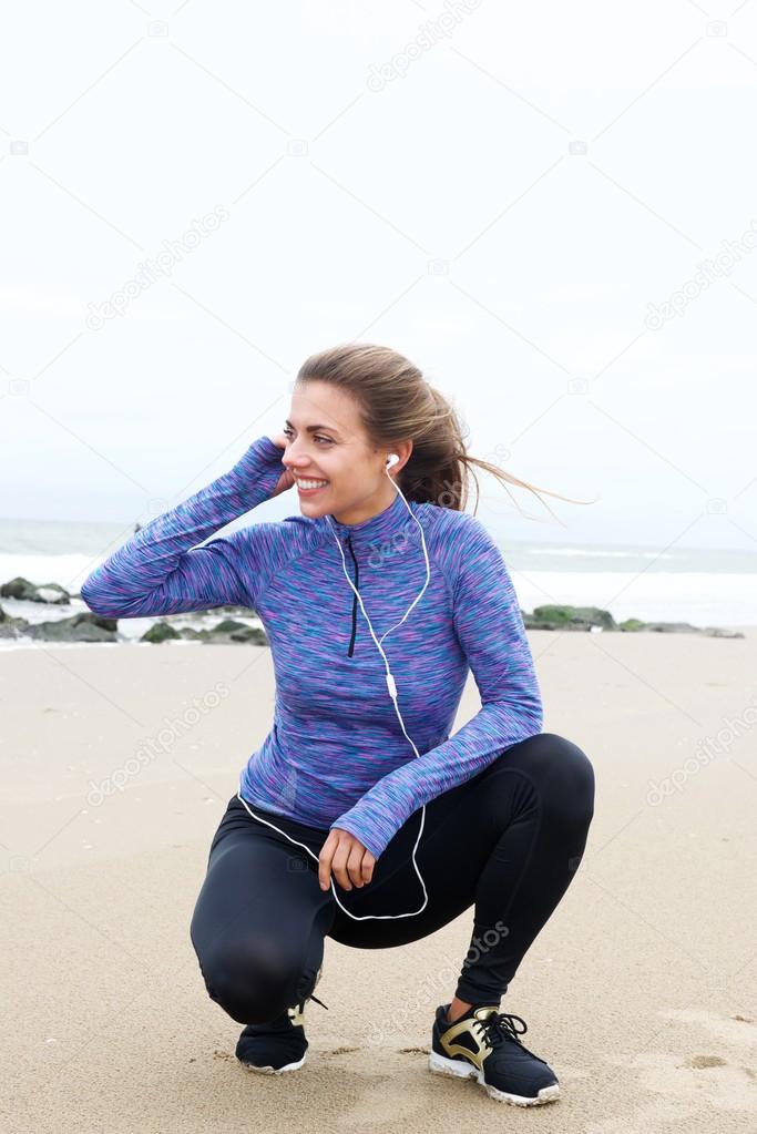 Woman crouching on beach