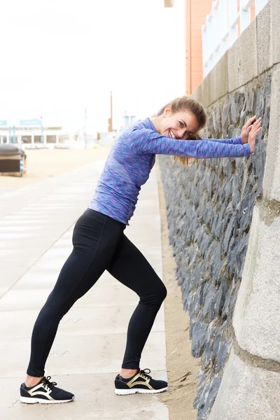 Atleta feminina em alongamento na calçada — Fotografia de Stock