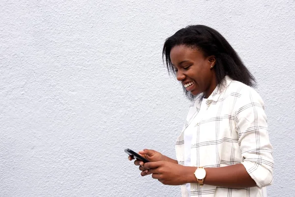 Joven mujer africana mensajes de texto amigos — Foto de Stock