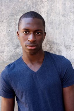 Adam ayakta agaisnt gri duvar