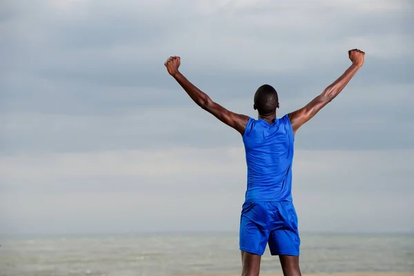 Homme sur la plage célébrant le succès — Photo