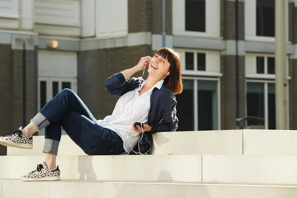 Frau sitzt auf Stufen und hört Musik — Stockfoto