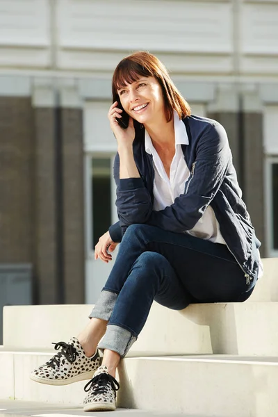 Vrouw zittend op stappen met behulp van de telefoon — Stockfoto