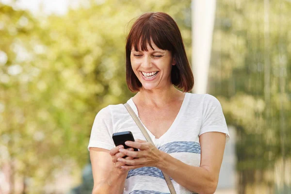 Mulher rindo mensagens no telefone — Fotografia de Stock