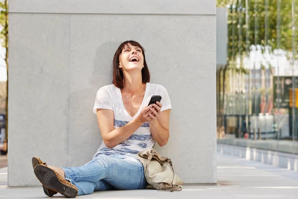 Mulher sentada no chão com telefone — Fotografia de Stock