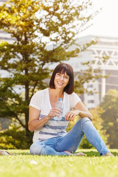 Donna che beve acqua al parco — Foto Stock