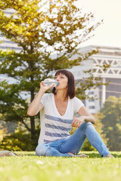 Femme eau potable au parc — Photo