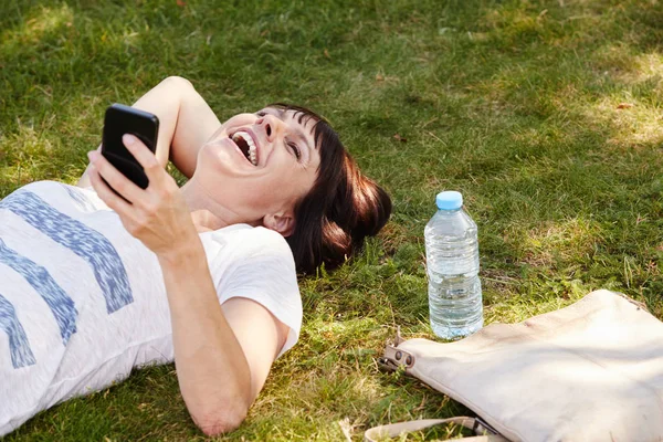 Mooie vrouw liggen in gras — Stockfoto