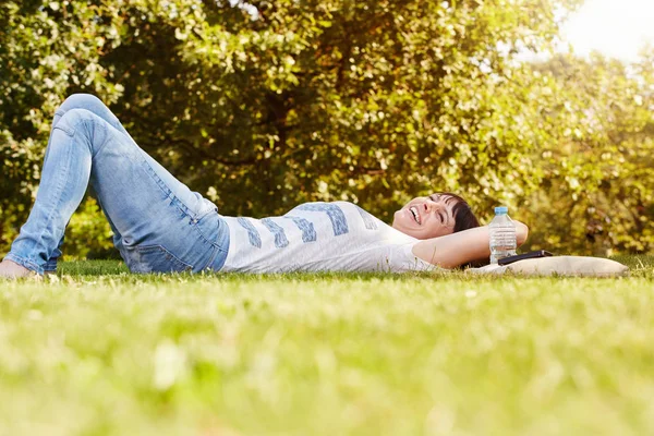 Donna sdraiata sull'erba in autunno — Foto Stock