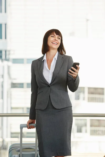 Woman standing in city with luggage — Stock Photo, Image