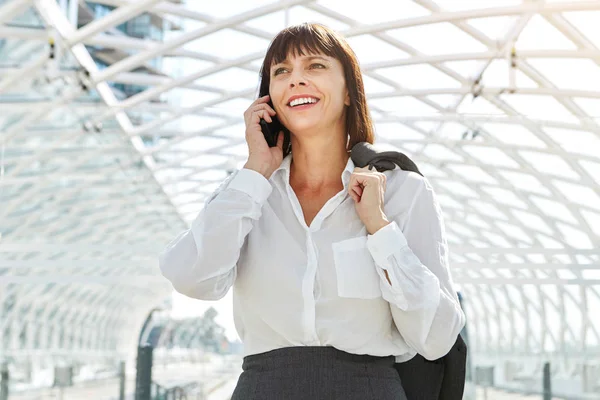 Vrouw praten over cellphone in station — Stockfoto