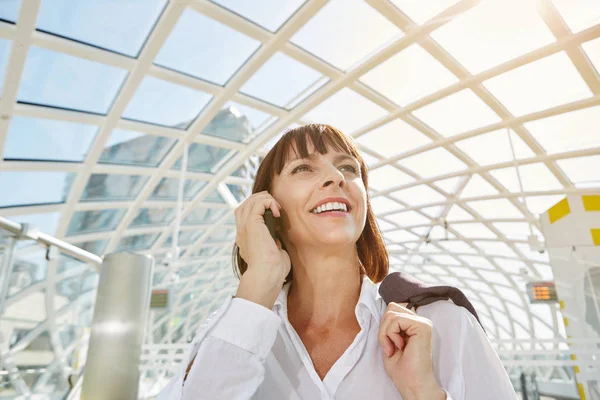 Vrouw praten over cellphone in station — Stockfoto