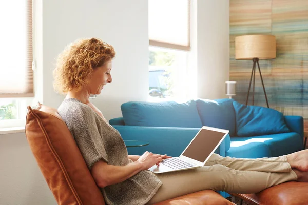 Vrouw in gezellig appartement met laptop — Stockfoto